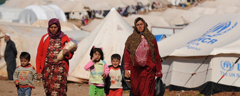 Syrian internally displaced people walk in the Atme camp, along the Turkish border in the northwestern Syrian province of Idlib, on March 19, 2013. The conflict in Syria between rebel forces and pro-government troops has killed at least 70,000 people, and forced more than one million Syrians to seek refuge abroad. AFP PHOTO/BULENT KILIC        (Photo credit should read BULENT KILIC/AFP/Getty Images)